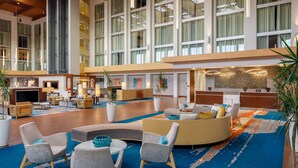 A spacious lobby with high ceilings, large windows, and a variety of seating arrangements including sofas and chairs. - DoubleTree by Hilton Pittsburgh - Cranberry (Mars)