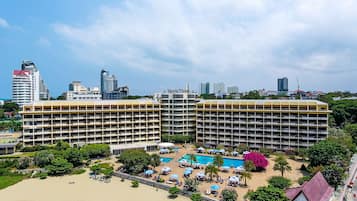 Een hotel met meerdere verdiepingen, een zwembad en een strandgedeelte.