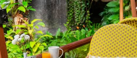 A breakfast table with various dishes, a coffee pot, and a glass of orange juice.