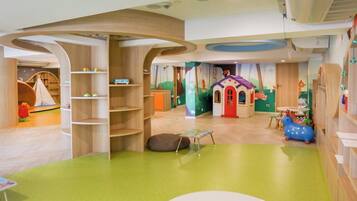 A children's playroom with wooden shelves, a slide, and a playhouse.