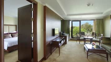 A hotel room with a bed, a TV, a desk, a sofa, and a balcony with a view.