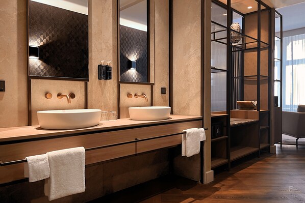 A modern bathroom with two sinks, a large mirror, and a wooden vanity.