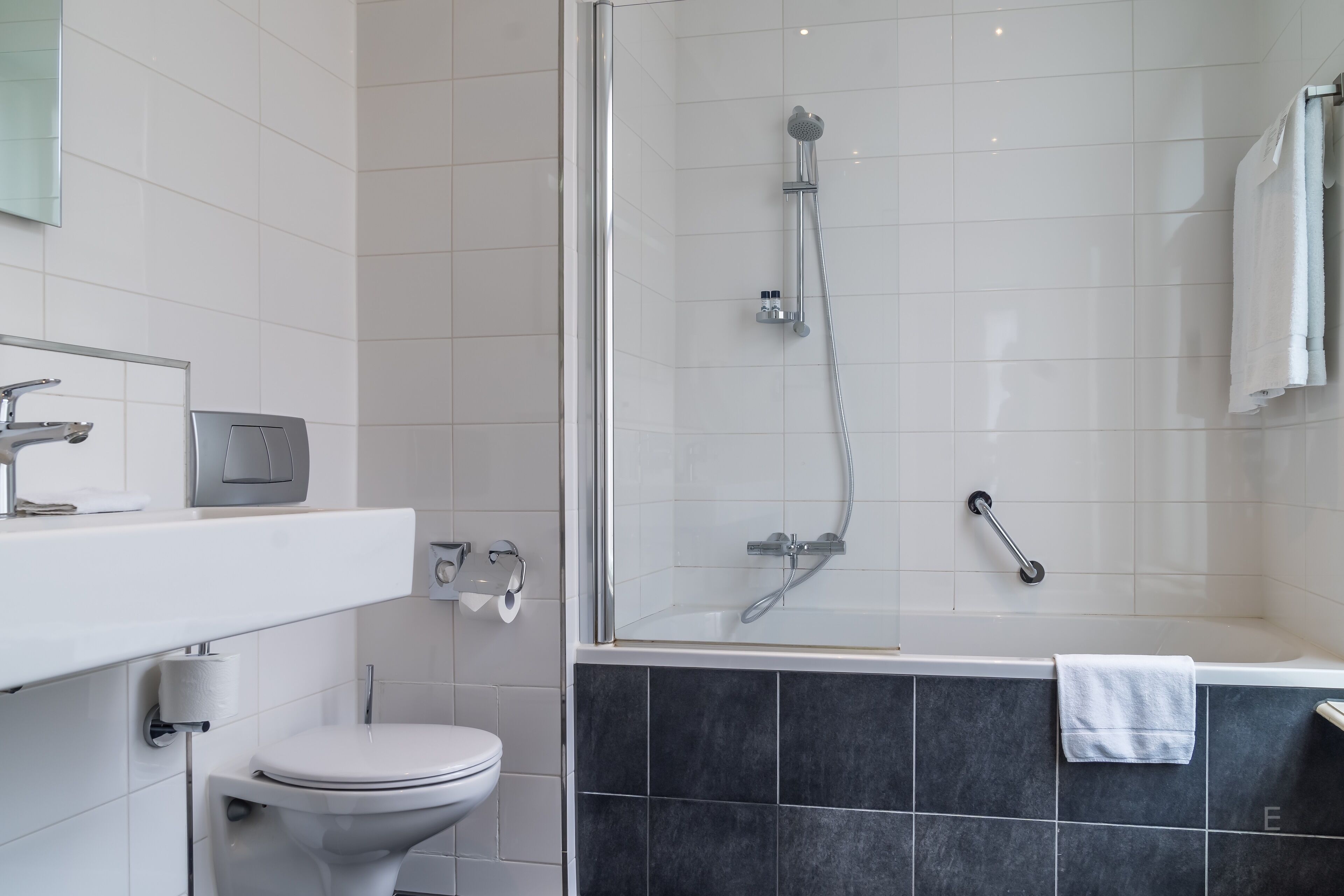 Un bagno moderno con WC, box doccia e vasca da bagno.