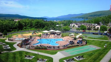 Relax by the pool surrounded by lounge chairs, tables, a playground, and shuffleboard court.