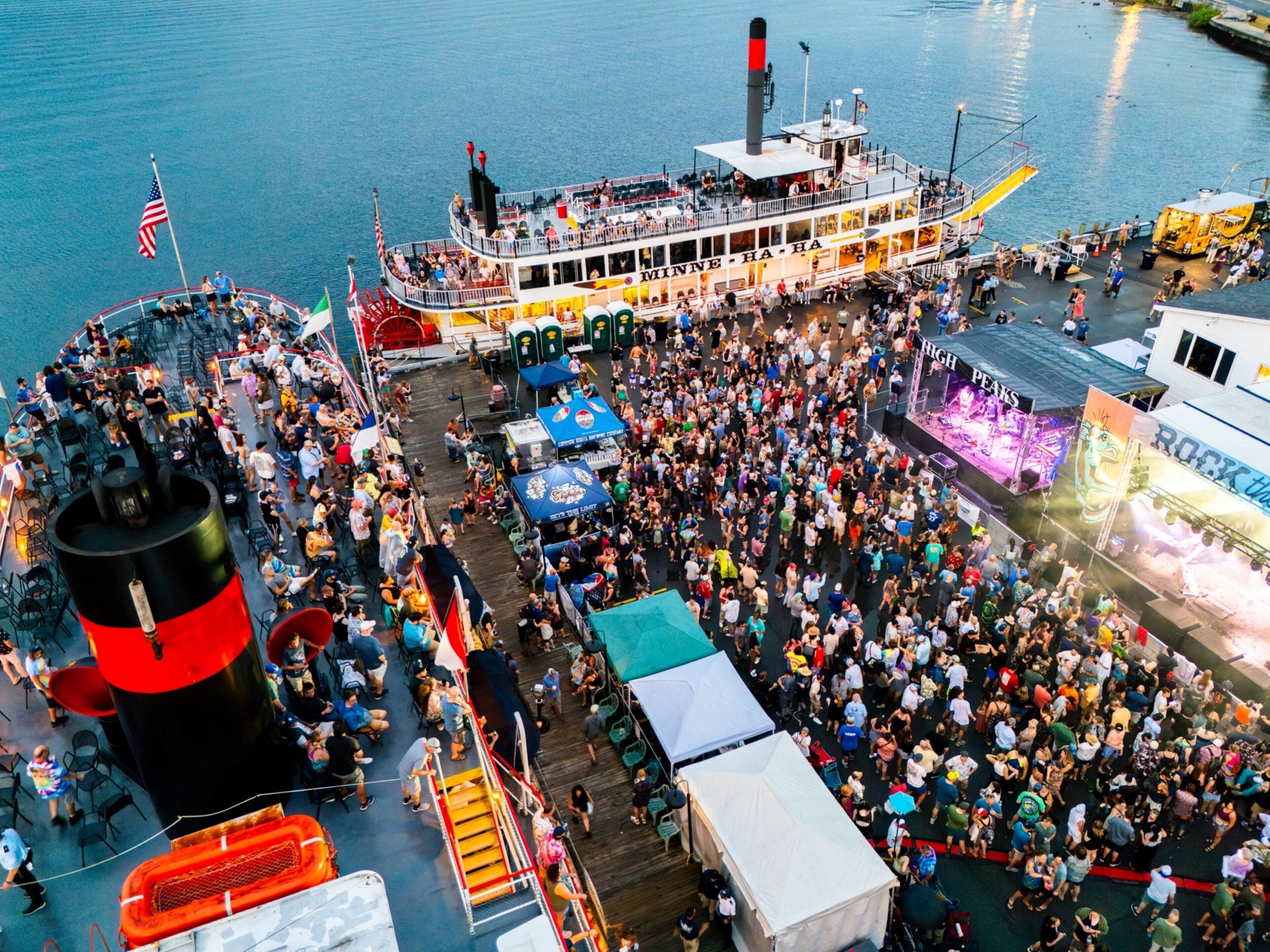 A large boat with multiple decks and a crowd of people on a dock.