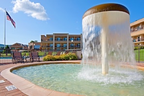 Enjoy a refreshing dip in the hotel's circular pool, surrounded by a central fountain and scenic views of the surrounding multi-story building.