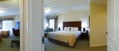 A hotel room with a large bed, a desk, a chair, and a television.