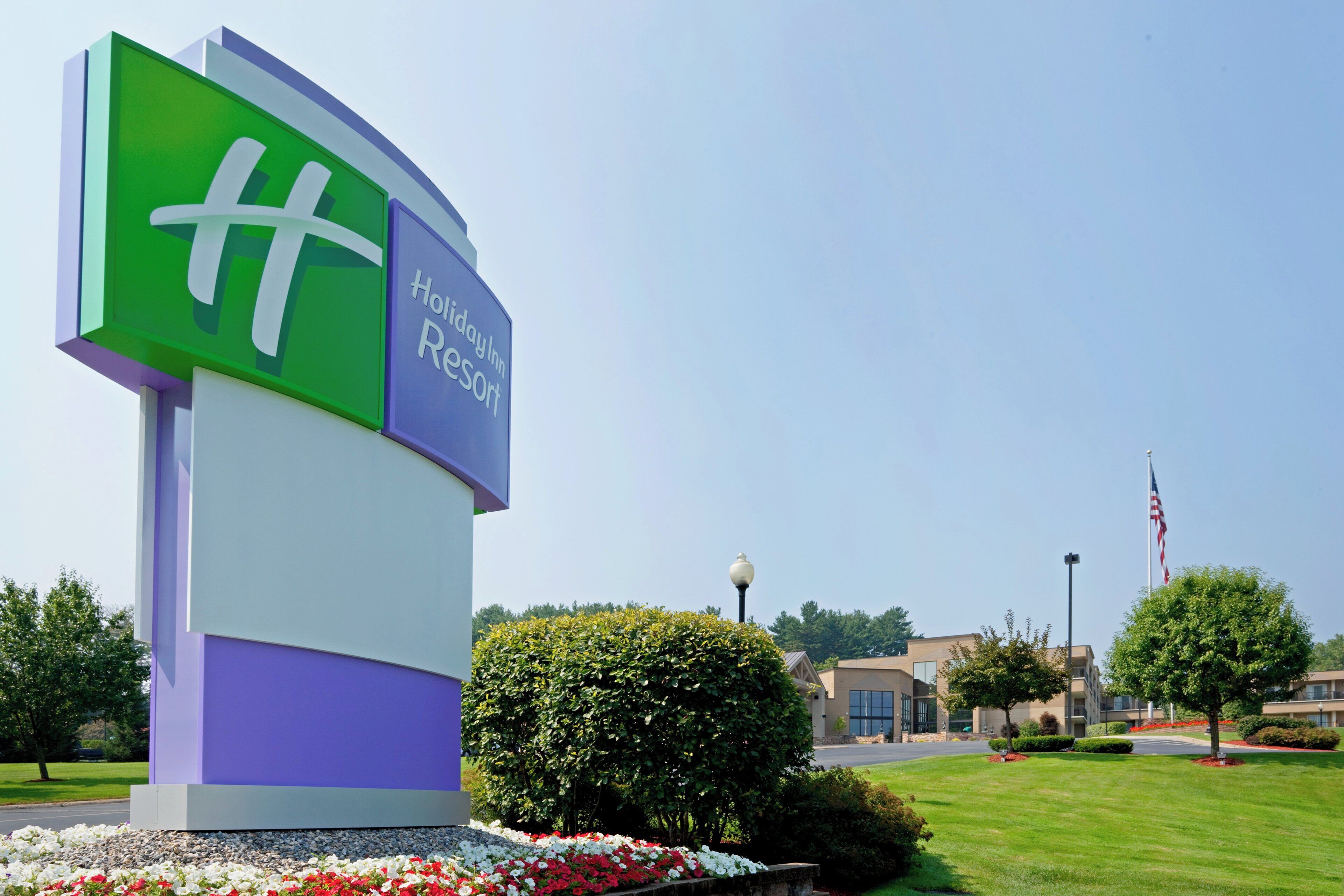 A large sign for Holiday Inn Resort with a clear view of the surrounding landscaped area.