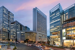 A modern hotel with a curved facade, large windows, and a prominent entrance. - Hilton Osaka (Osaka)