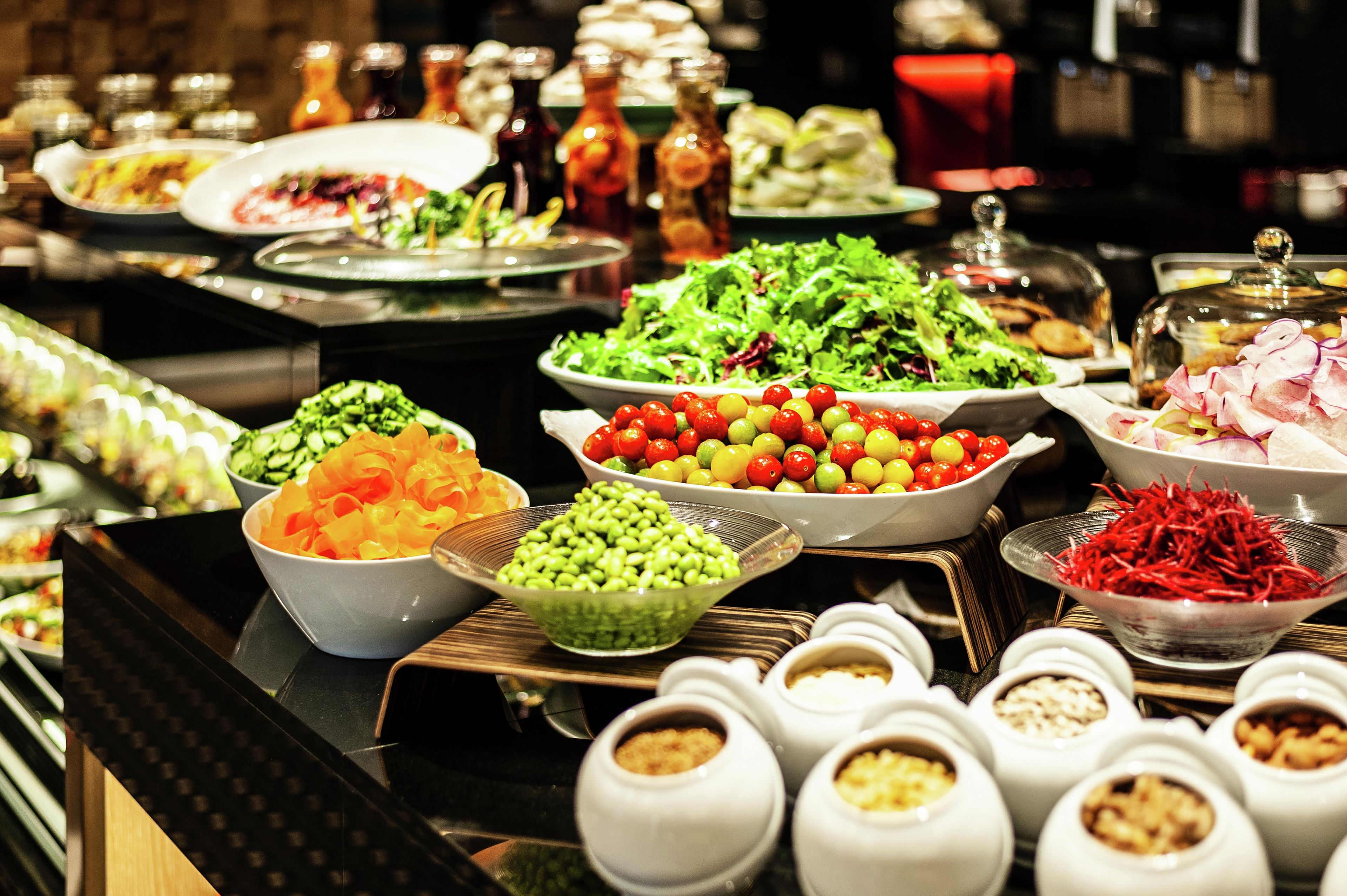 A buffet with various dishes and condiments.