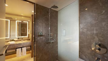 A modern bathroom with a glass-enclosed shower, a vanity with a mirror, and a bathtub.