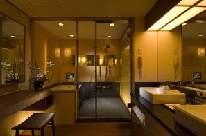 A modern bathroom with a glass-enclosed shower, a vanity with a sink, and a bench. - Hilton Osaka (Osaka)