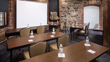 A conference room with a large whiteboard, wooden tables, and chairs.