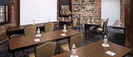 A conference room with a large whiteboard, wooden tables, and chairs.