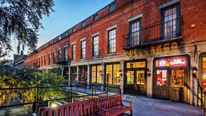 A red brick building with a bench in front.