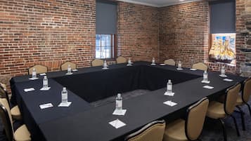 A conference room with a long table, chairs, water bottles, and name cards.