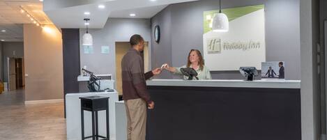 A reception desk with a modern design, a clock, and a sign for 'The Inn'.