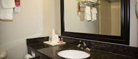 A bathroom with a sink, mirror, and towel rack.