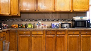 A kitchen with wooden cabinets, a microwave, and various kitchen appliances. - New Victorian Inn Norfolk (Norfolk)