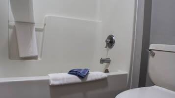 A bathroom with a bathtub, a toilet, and a towel rack.