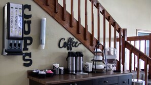 A kitchen counter with coffee-making equipment, a coffee sign, and a knife holder. - New Victorian Inn Norfolk (Norfolk)