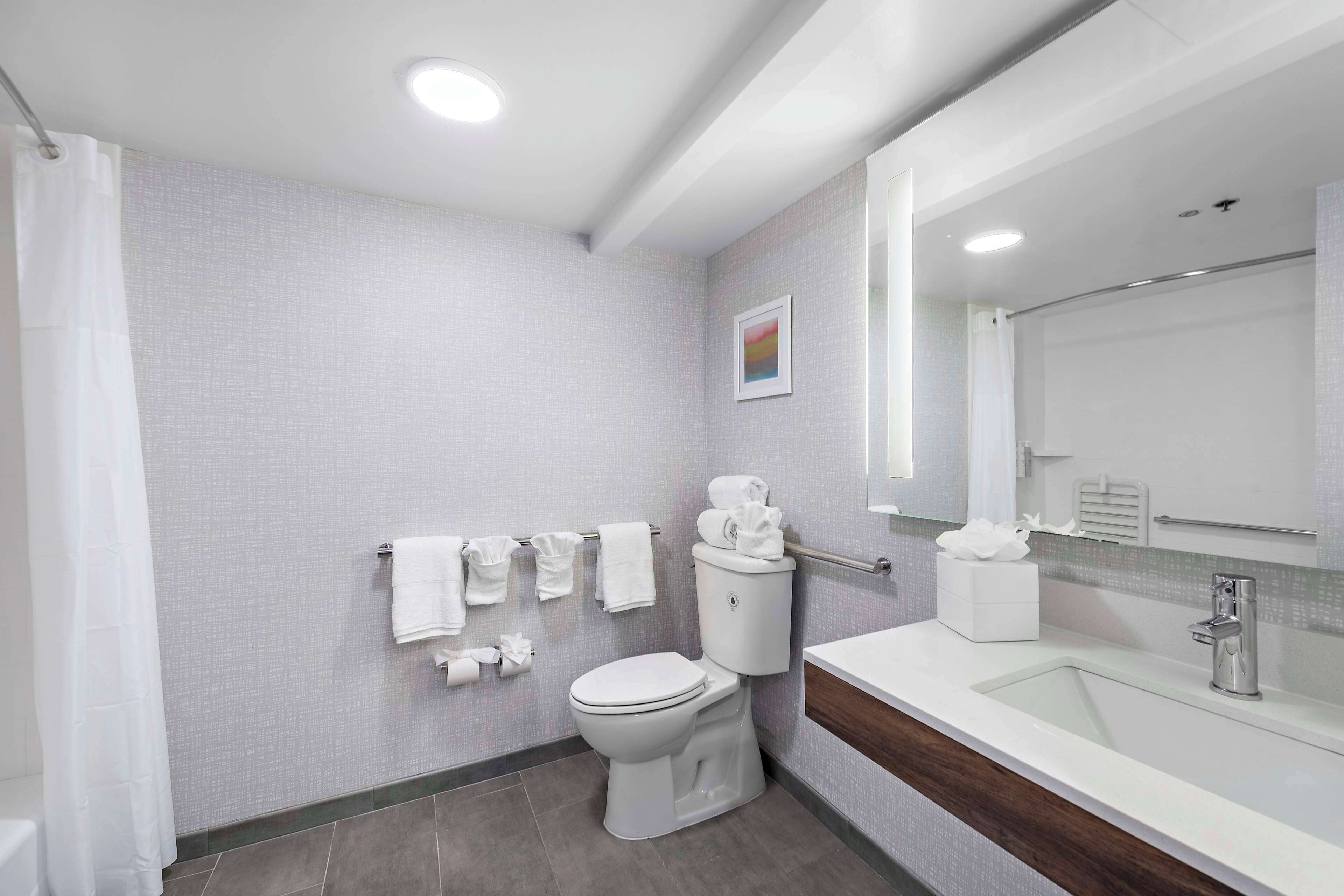 A modern bathroom with a toilet, sink, and shower.