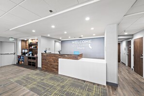 A reception area with a 'WELCOME TO THE GOLDEN STATE' sign, a counter, and a coffee machine. - Hampton Inn by Hilton Los Angeles Airport LAX (Inglewood)