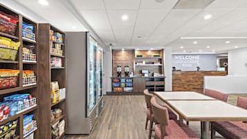 A modern indoor space with a reception area, a snack bar, and seating.