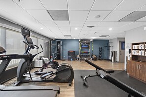 A gym with exercise equipment, a water dispenser, and a view of the city. - Hampton Inn by Hilton Los Angeles Airport LAX (Inglewood)