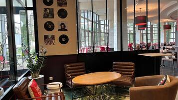 Un interior moderno con una mesa redonda, sillas de cuero y una pared decorada con discos de vinilo.