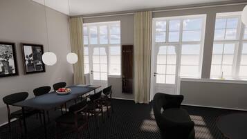 A room with a dining table, chairs, a large window with curtains, and artwork on the wall.