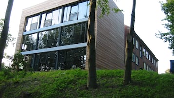 Ein modernes Gebäude mit Glasfassade, großen Fenstern und flachem Dach.