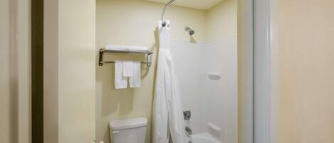 A bathroom with a toilet, a bathtub, and a shower curtain.