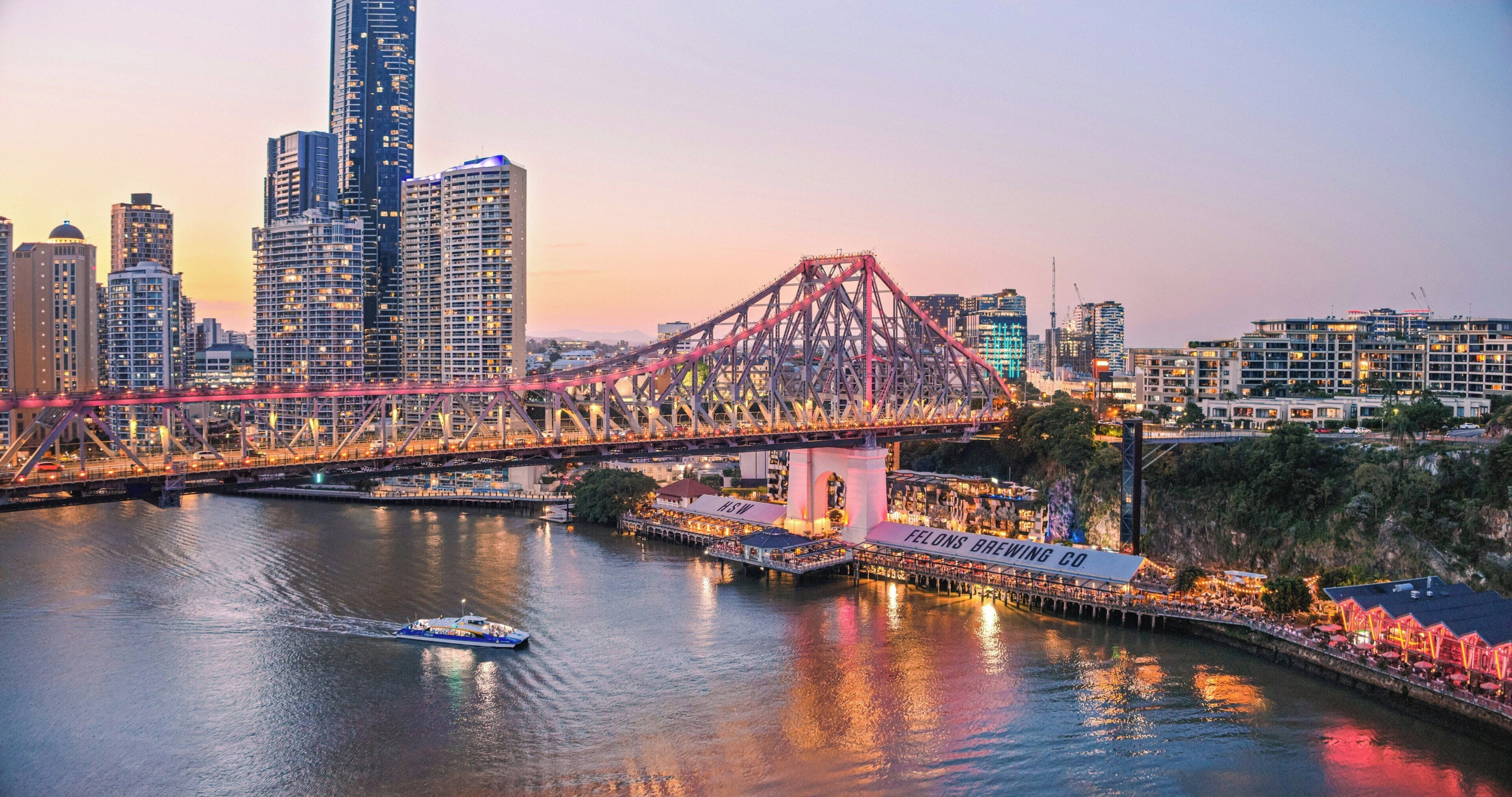 A cityscape with a prominent bridge, a waterfront area, and a boat.