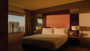 A hotel room with a large bed, a nightstand with a lamp, a window with curtains, and a city view. - InterContinental Brisbane by IHG (Brisbane)