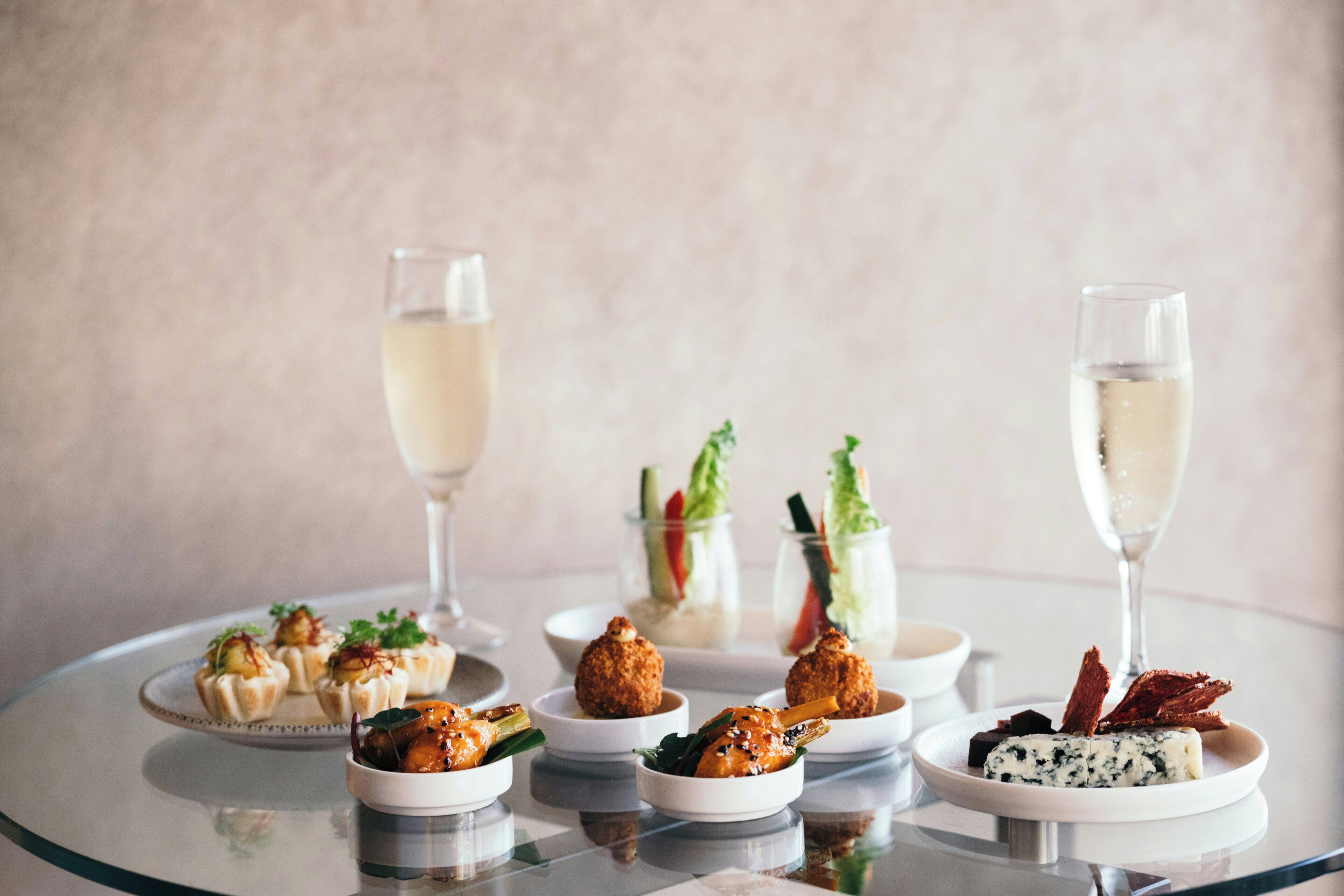 A table with various dishes and glasses of a clear liquid, likely water or a non-alcoholic beverage.