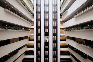 A multi-level atrium with a central elevator shaft, surrounded by balconies with greenery. - InterContinental Brisbane by IHG (Brisbane)