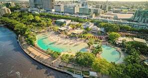 A coastal resort with a large pool, surrounded by lush greenery and modern buildings. - InterContinental Brisbane by IHG (Brisbane)