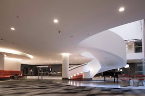 A modern interior with a spiral staircase, seating areas, and a check-in desk. - InterContinental Brisbane by IHG (Brisbane)