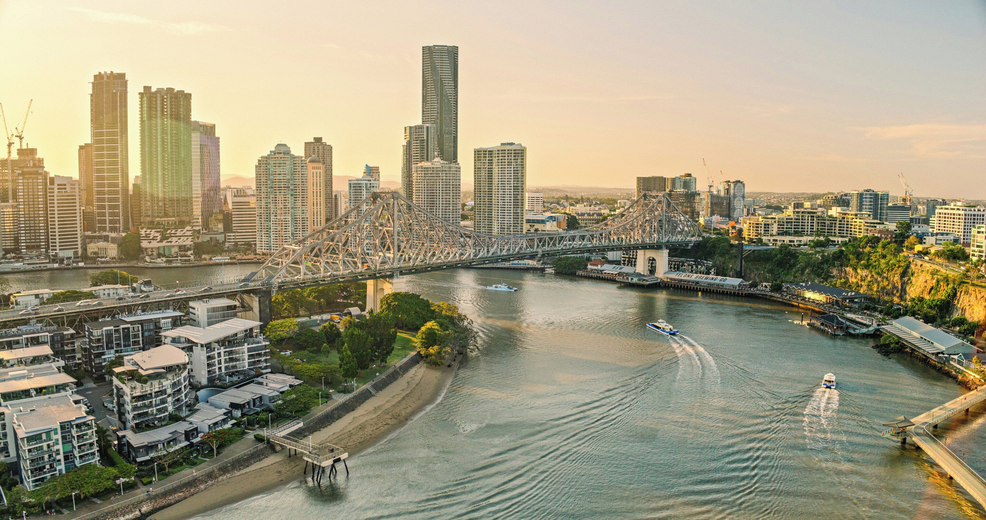 A cityscape with a prominent bridge, high-rise buildings, and a river.