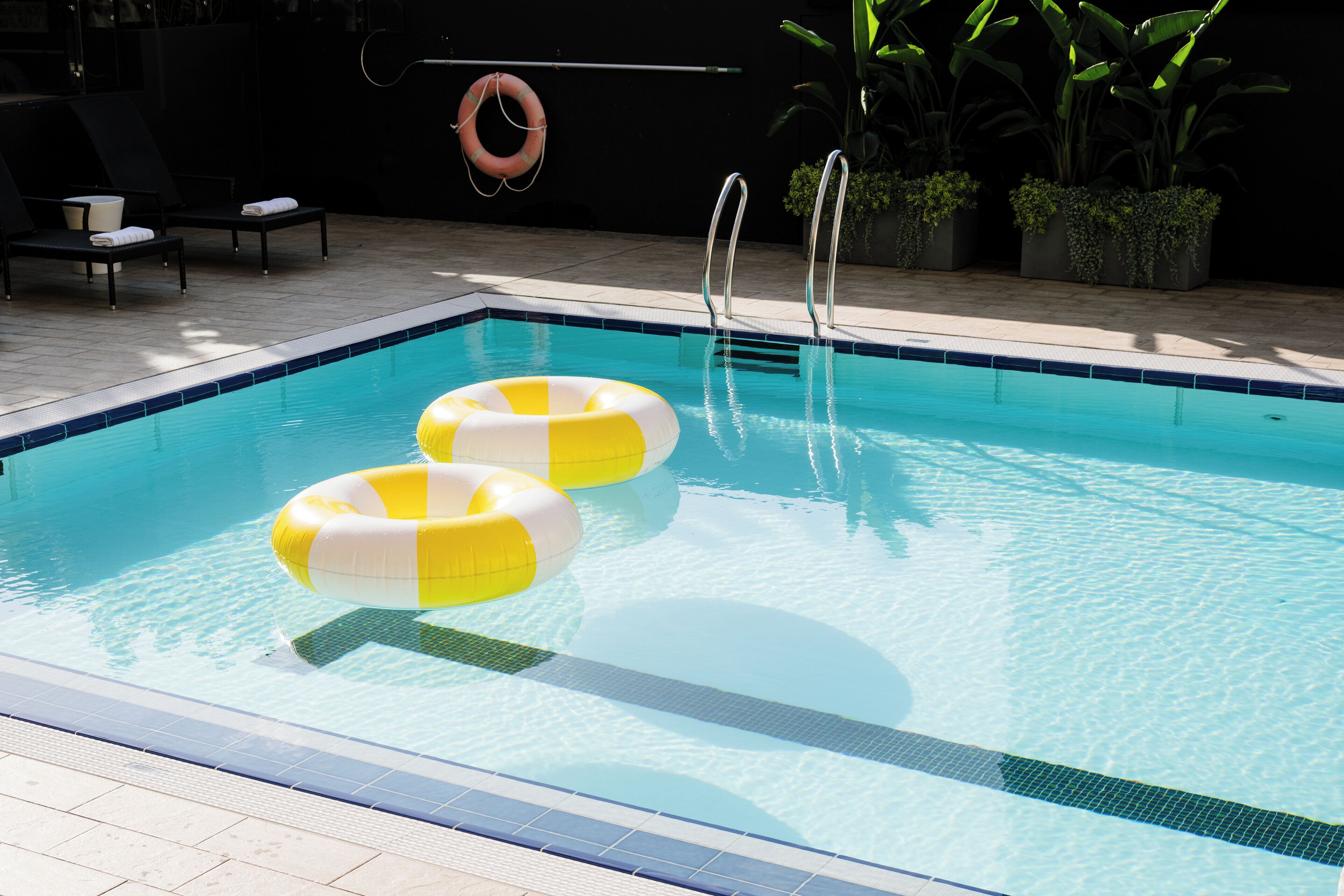 Een buitenzwembad, parasols voor strand/zwembad