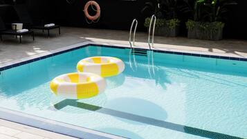 Een buitenzwembad, parasols voor strand/zwembad