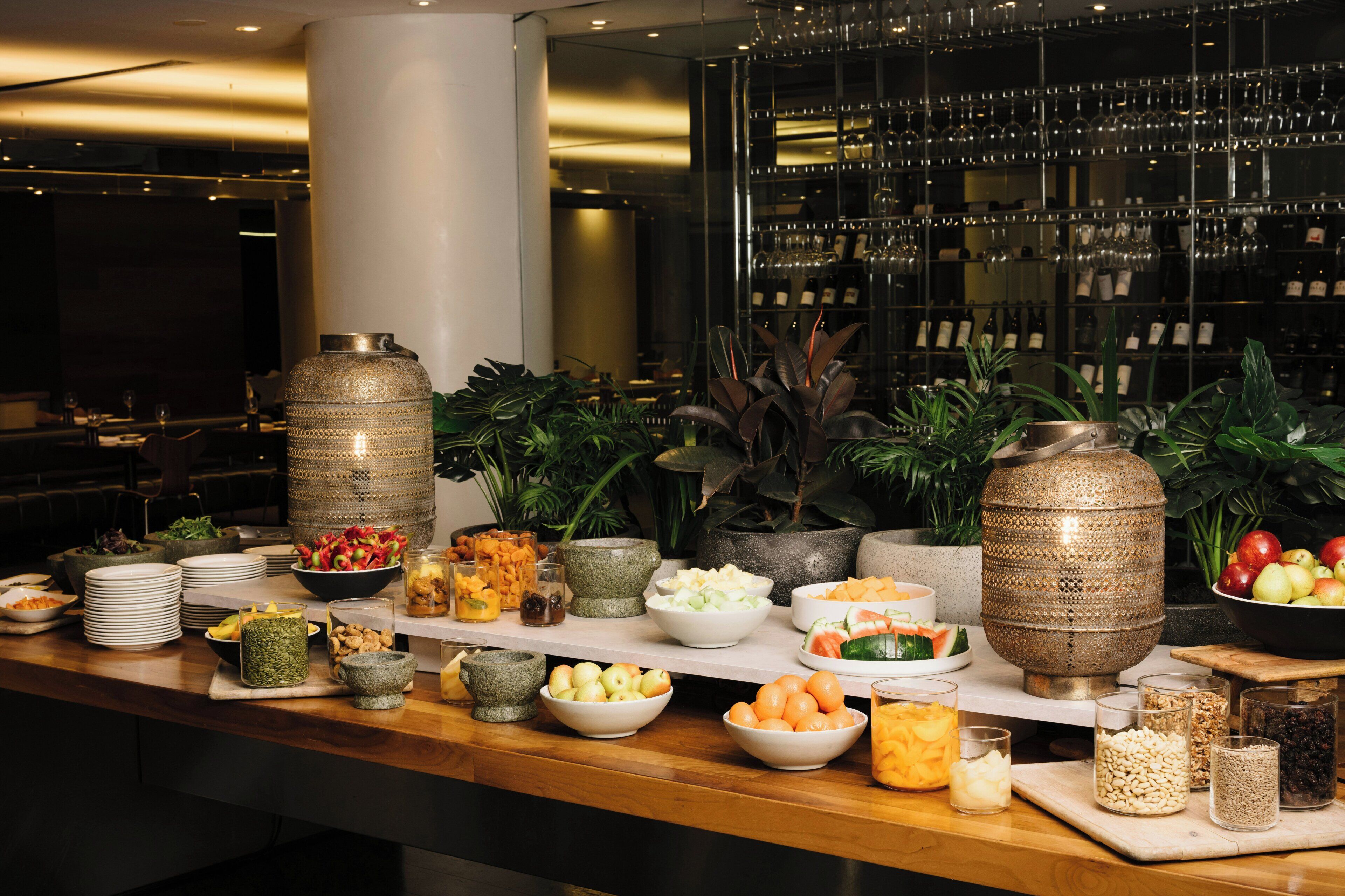 A buffet table with various food items and decorative vases.