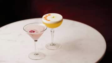 Two cocktails on a white marble table.