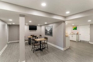 Un interior moderno con comedor, cocina y televisor de pantalla plana en la pared.