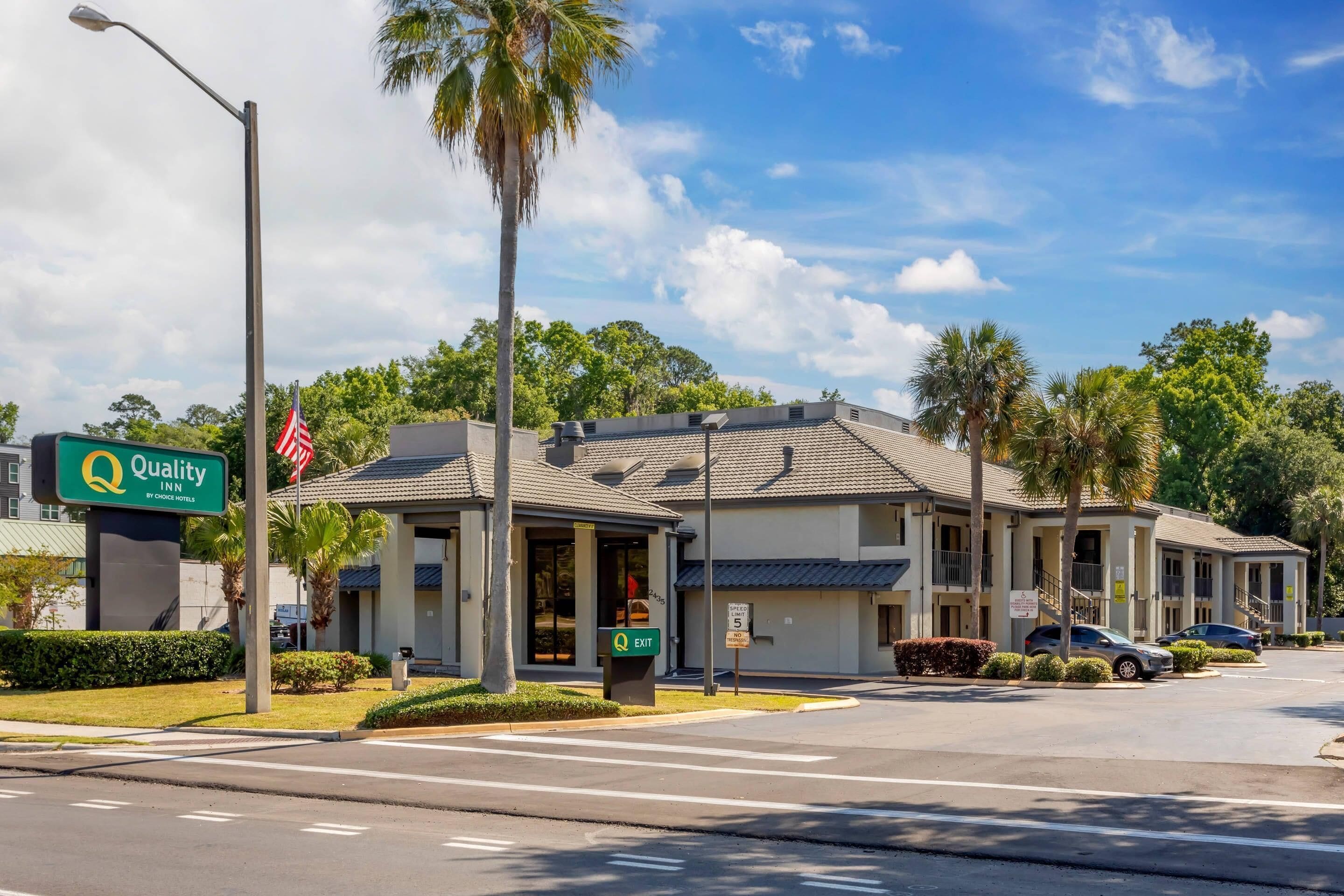A two-story motel with a sign indicating it is a Quality Inn by Choice Hotels.