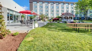 A courtyard with outdoor seating, a gazebo, and a building with multiple windows. - Holiday Inn Piscataway Somerset by IHG (Piscataway)
