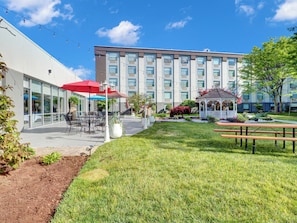 A courtyard with outdoor seating, a gazebo, and a building with multiple windows. - Holiday Inn Piscataway Somerset by IHG (Piscataway)