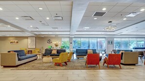 A spacious lobby with a modern design, featuring sofas, chairs, and a large rug. - Holiday Inn Piscataway Somerset by IHG (Piscataway)