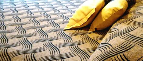 A bed with a patterned bedspread and two pillows.